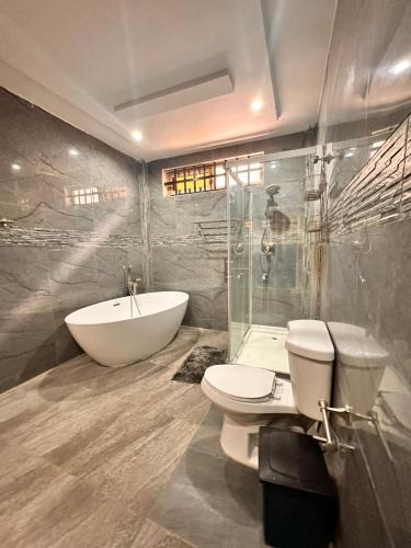 a bathroom with a sink and a toilet and a tub at Amina luxury suites in Lomé