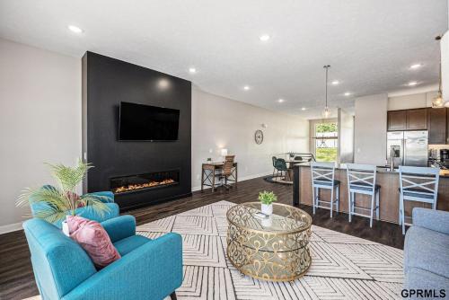 un soggiorno con un divano blu e un camino di Midtown Luxury - 2 Master Suites - Near UNMC a Omaha