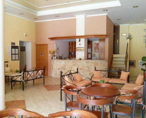 a lobby with tables and chairs and a bar at Asteras hotel in Hanioti