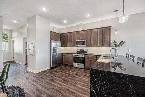 una cucina con mobili in legno e un piano di lavoro di Midtown Luxury - 2 Master Suites - Near UNMC a Omaha