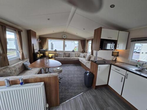 a kitchen and living room with a couch and a table at Superb 8 Berth Caravan At St Osyth Beach, Essex Ref 28001G in Jaywick Sands