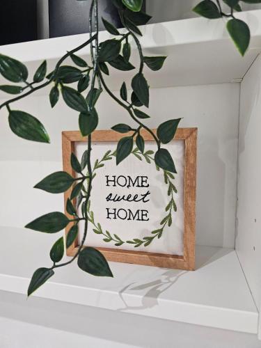a picture of a home sweet home sign in a wooden frame at Blue Star Studio in Tierras Nuevas Poniente
