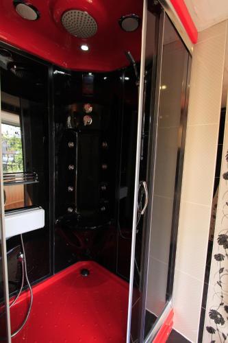 a shower with a red floor and a glass door at Coskun apt in Istanbul