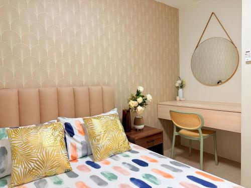 a bedroom with a bed and a desk and a mirror at 2-Bedroom Cozy Haven Sorrento Oasis in Manila