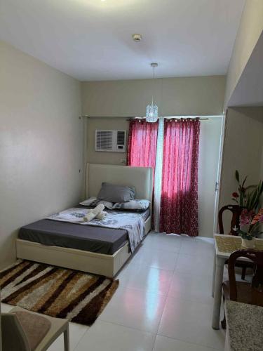 a bedroom with a bed and a red window at Sunvida Tower staycation unit 2503-2504 in Cebu City