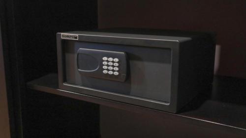 a microwave oven on a shelf in a room at JL World Hotel Dili in Dili
