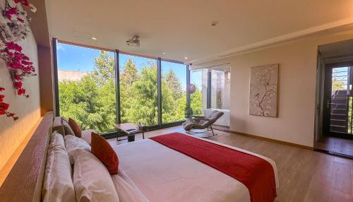 a bedroom with a large bed and large windows at Villa LOHERB in Dongshan