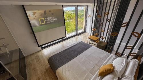 a bedroom with a large window and a large screen at Villa LOHERB in Dongshan