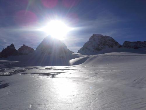 a snow covered mountain with the sun behind it at Vermunt - Silvretta Sommer Premium Card inklusive in Galtür