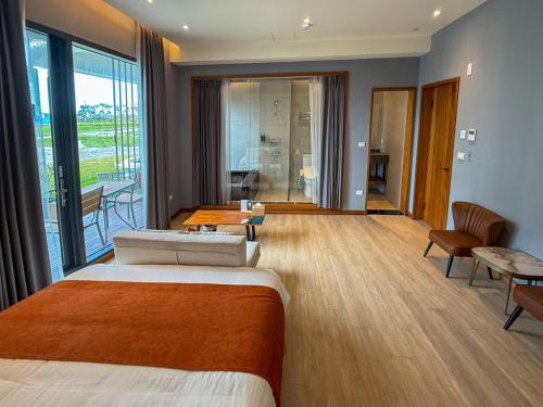a hotel room with a bed and a balcony at Villa LOHERB in Dongshan