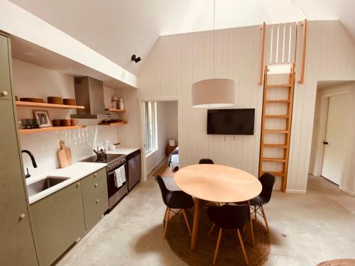 a kitchen with a table and chairs in a room at Fern's Edge in Port Renfrew