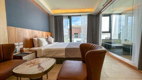 a hotel room with a bed and a table and chairs at Villa LOHERB in Dongshan