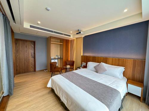 a bedroom with a large bed with a blue wall at Villa LOHERB in Dongshan