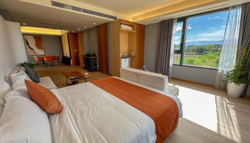 a bedroom with a large bed and a large window at Villa LOHERB in Dongshan