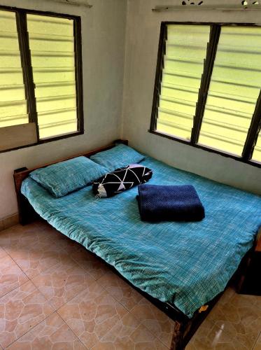 a bed in a room with two pillows on it at Devalley Basecamp in Kampong Ulu Dong