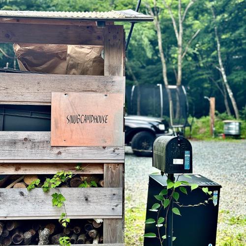 a wood fence with a sign that reads sun compromise at SNUG CAMP HOUSE in Okubo