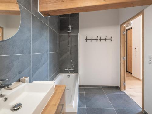a bathroom with a white tub and a sink at Appartement moderne aux pieds des pistes, Alpe d'Huez - FR-1-645-92 in L'Alpe-d'Huez