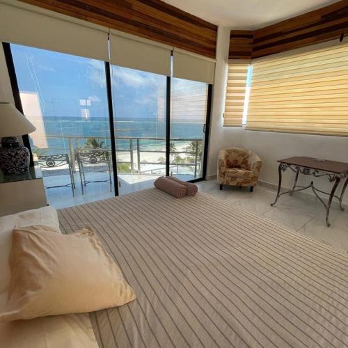 a bedroom with a bed with a view of the ocean at MoonLight Condos in Puerto Morelos