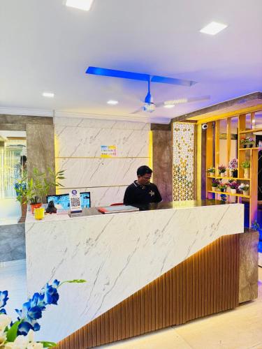 a man sitting at a counter in a restaurant at hotel KGB Legend Grand in Visakhapatnam