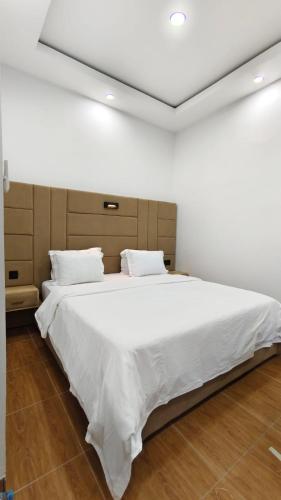 a bedroom with a large bed with white sheets at Villa Dalia Puncak ACC9-18 in Cikujang