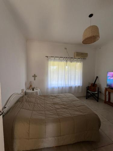 a bedroom with a large bed and a television at Posada El Descanso in Mercedes