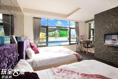 a bedroom with two beds and a large window at Shuian Lakeside Hotel in Yuchi