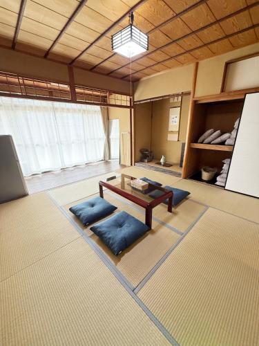a room with a table and blue cushions in it at ヒトシズク in Otsu