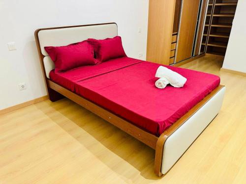 a bed with red sheets and a white towel on it at Levy-Cardoso Apartment in Praia