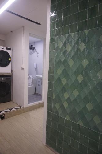 un bagno con una parete piastrellata verde con un water di ACE Hostel a Hanoi