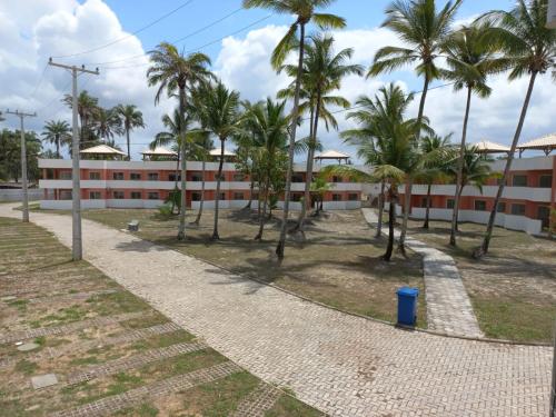 an empty street in front of a building with palm trees at Lindo apto em frente ao Mar - Ilhéus - Itacaré Ba in Ilhéus