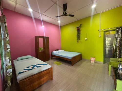 a room with two beds and colorful walls at New Kaziranga Cottage in Kāziranga