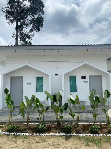 a white building with windows and plants in front of it at 1108 Pedas Village Resort in Pedas