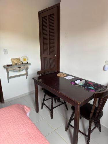 a wooden table in a room with a bed at Casa Jardim 2 in Miguel Pereira