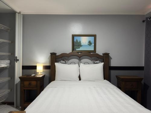a bedroom with a large bed with white pillows at Stada San Jose Airport Hotel in Alajuela City