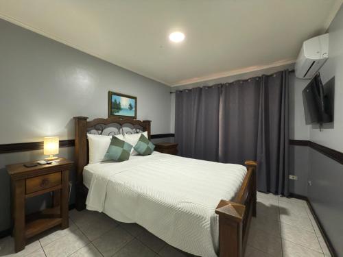 a bedroom with a large bed and a television at Stada San Jose Airport Hotel in Alajuela City