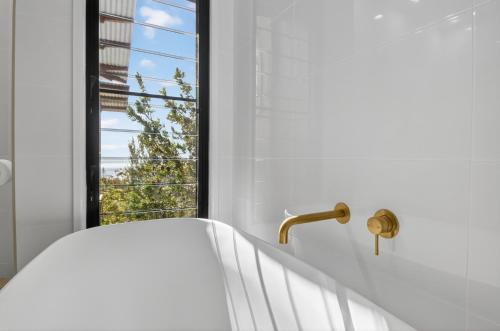 a bathroom with a white tub and a window at Moreton View @ Tangalooma in Tangalooma