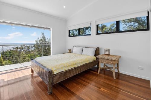 a bedroom with a bed and a large window at Moreton View @ Tangalooma in Tangalooma