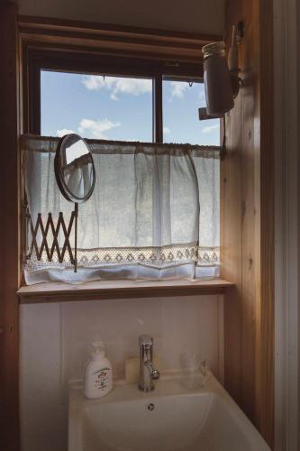 a bathroom with a sink and a window with a mirror at yogahouse in Mine