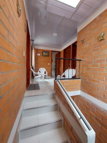 a hallway with stairs and a brick wall at Casa Vacacional Paipa in Paipa