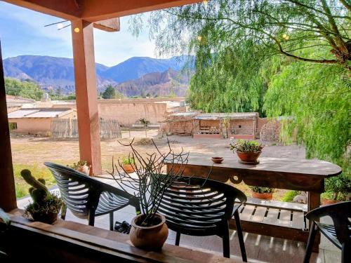 a table and chairs on a porch with a view of a yard at Guasamayo in Tilcara