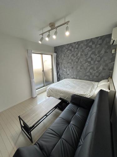 a living room with a bed and a couch at Park side stay Shinjuku in Tokyo