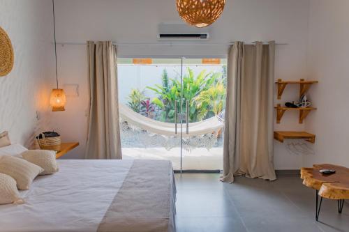 a bedroom with a bed and a large window at O Caminho das Dunas in Jericoacoara