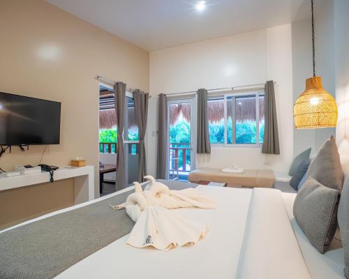 a living room with a white bed and a tv at Bathala Resort in Panglao