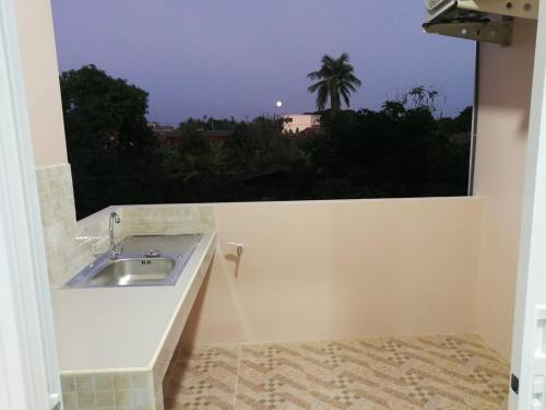a bathroom with a sink and a window at ศุภักษรอพาร์ทเม้นและสระว่ายน้ำ Supakson apartement and pools in Sawankhalok