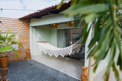 a hammock hanging on the side of a house at O Caminho das Dunas in Jericoacoara