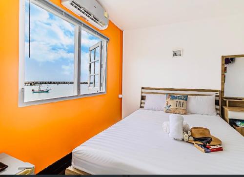 a bedroom with an orange wall and a bed with a window at Karoon Sea View Lodge in Hua Hin