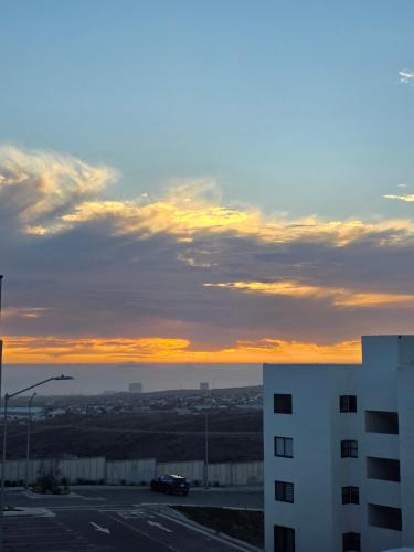 a sunset over a parking lot with a building at Rosarito Getaway - Mangle Condos in Rosarito