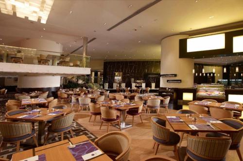 a restaurant with tables and chairs in a room at Grand Lisboa Macau in Macau