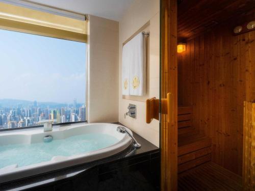 a bath tub in a bathroom with a large window at Grand Lisboa Macau in Macau