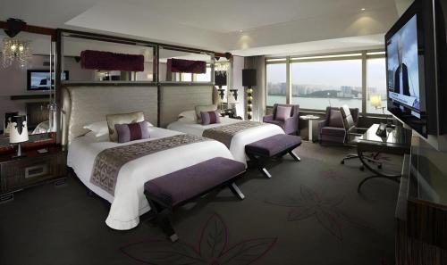 a hotel room with two beds and a television at Grand Lisboa Macau in Macau